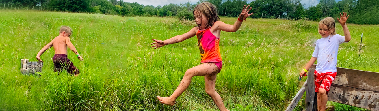 children in tall grass playing and laughing