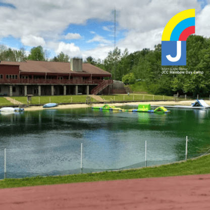 A lake with water slides and a lodge in the background.