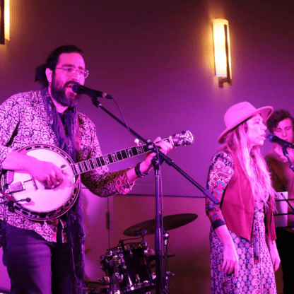 A group of people singing and playing a banjo.