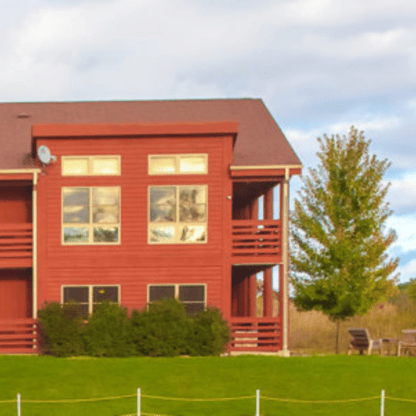 A red building sitting on a grassy field.