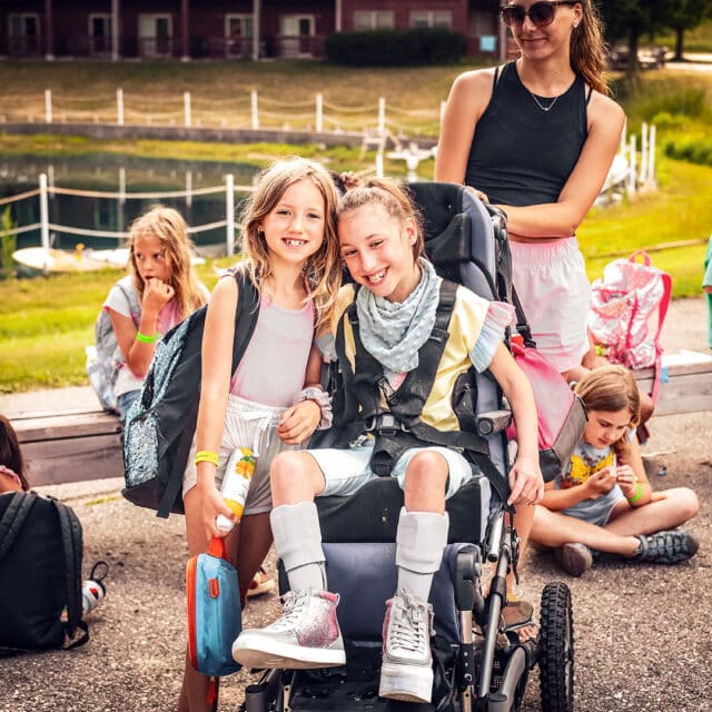 A girl in a wheelchair with a backpack.