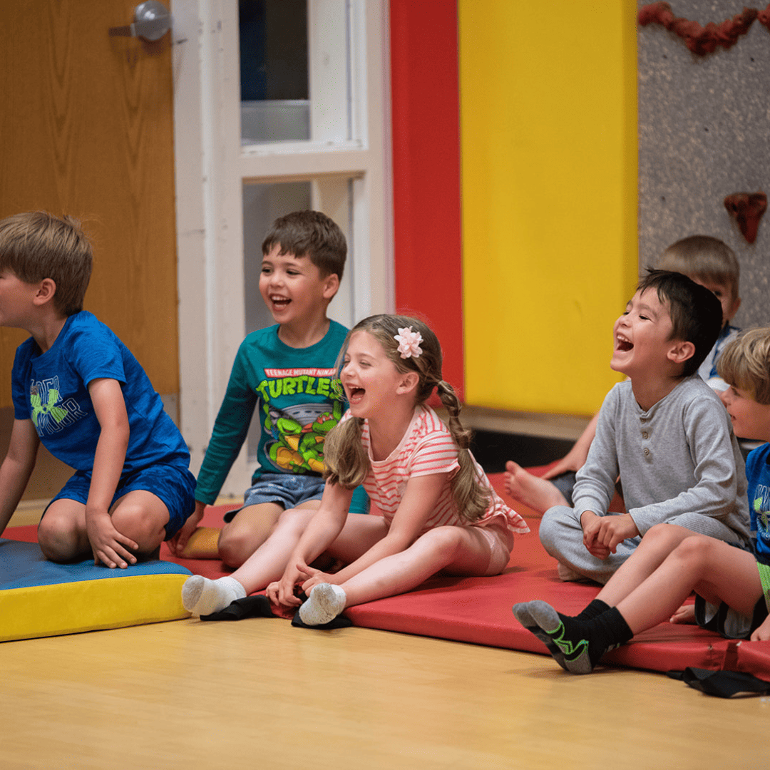 A group of children sitting on a mat.