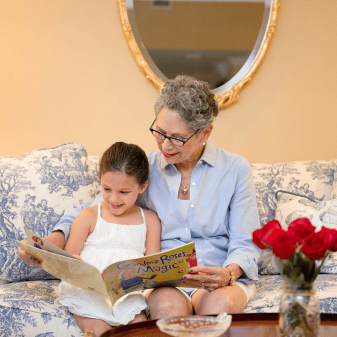 An older woman reading a book to a young girl.