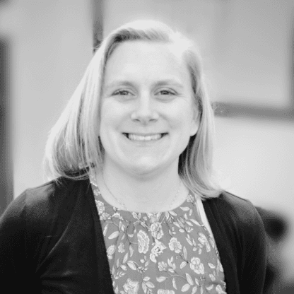 A black and white photo of a smiling woman.