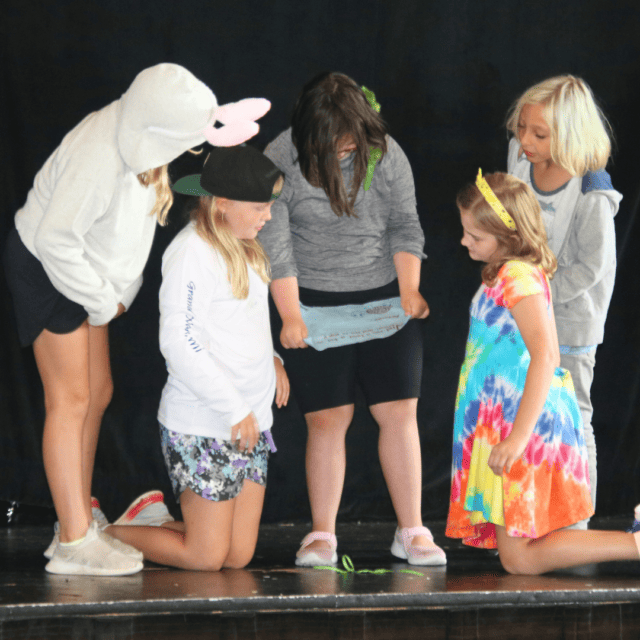 A group of girls standing on a stage.